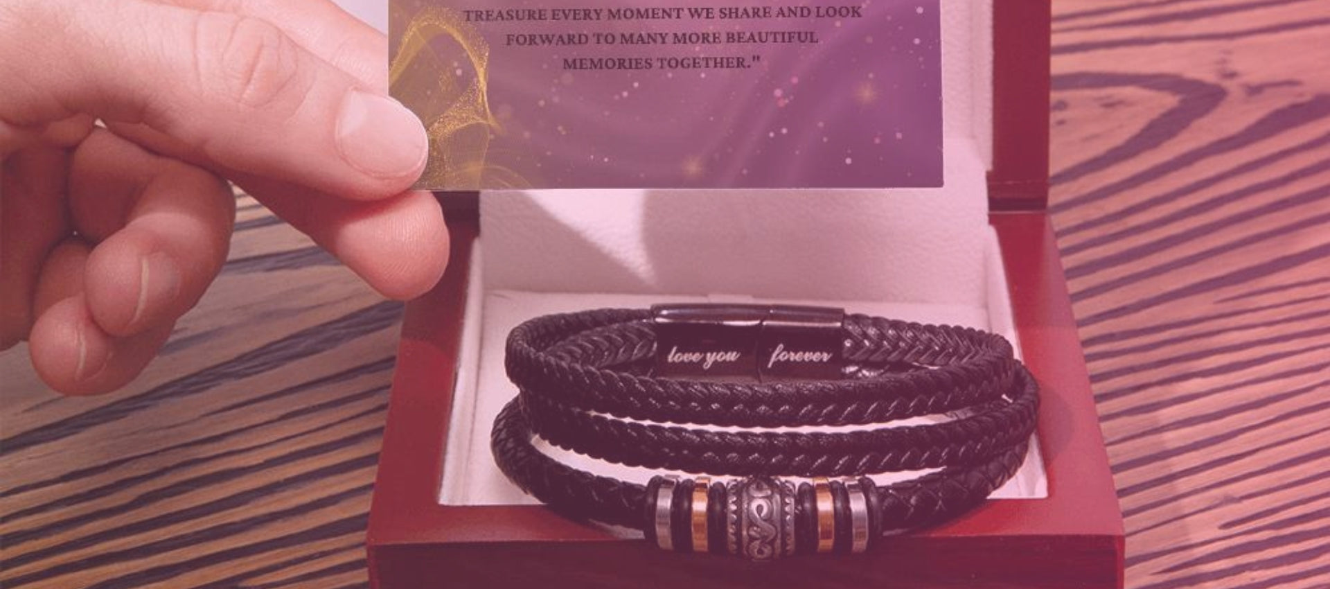 Close-up of a hand holding a card with a heartfelt message next to a leather Bracelets Boxin an elegant box, engraved with 'love you forever', symbolizing lasting affection and memories.