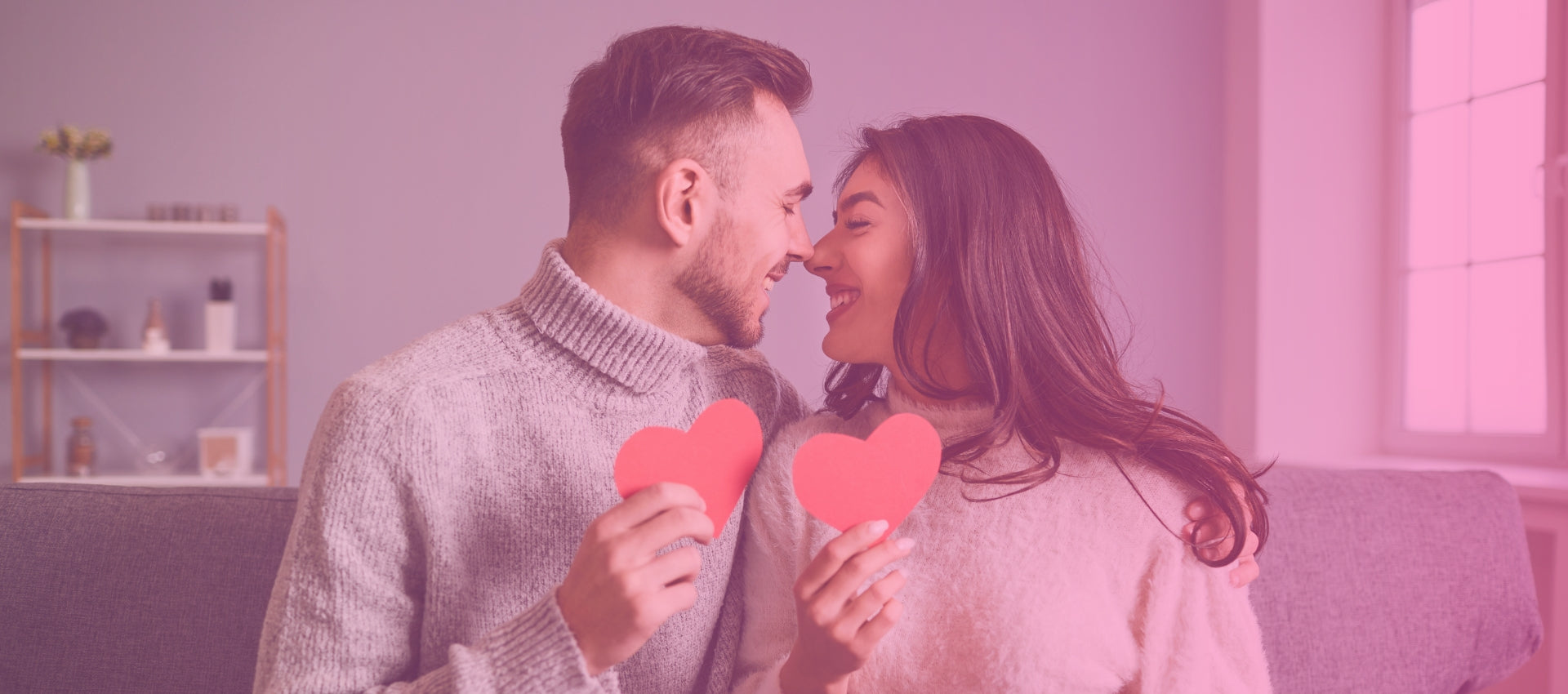 Happy couple enjoying a romantic Valentine's Day dinner with candles and roses